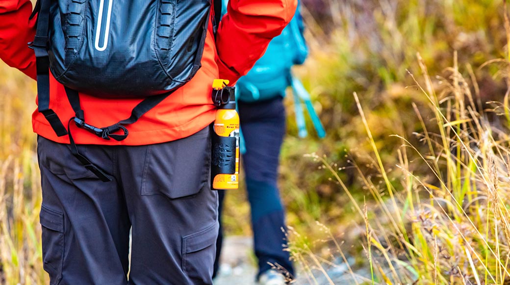 Bear spray self-defence attached to backpackers when hiking