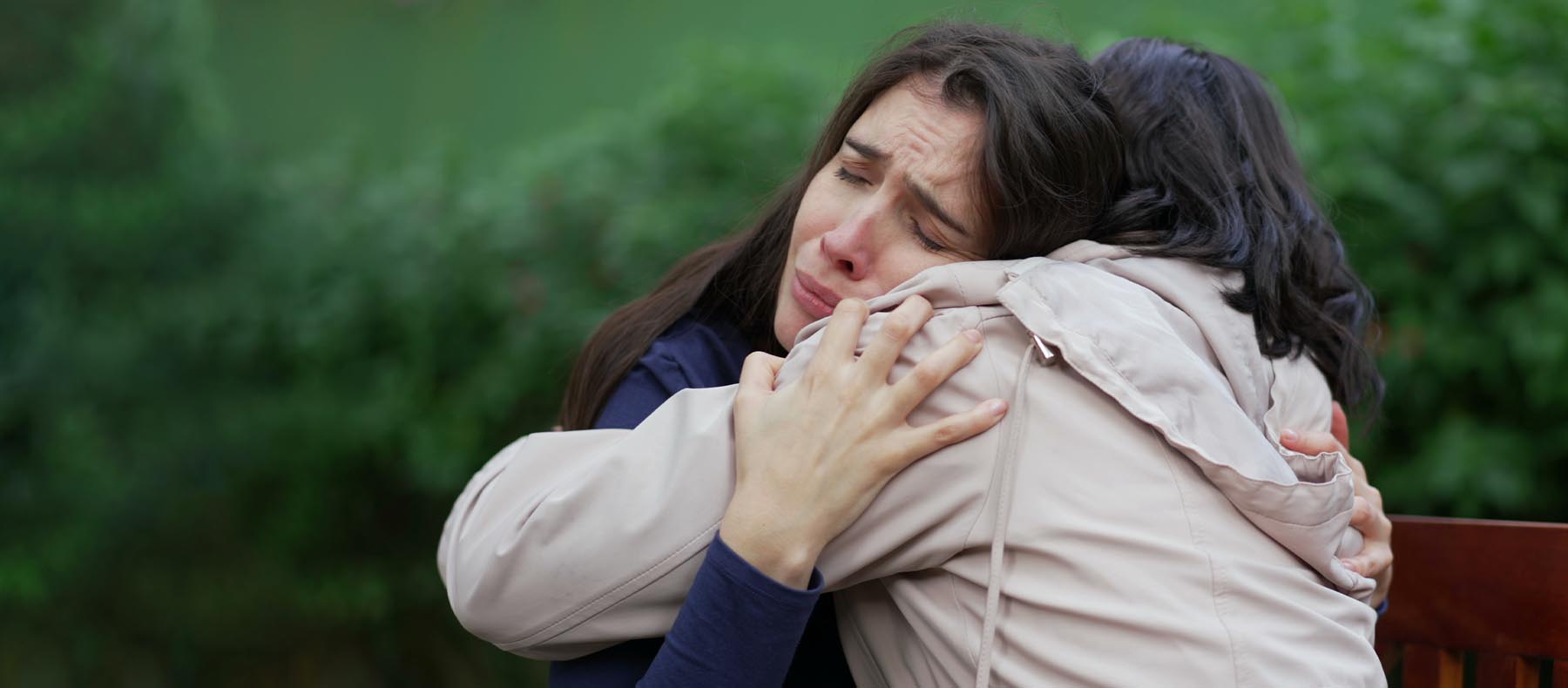 Two women embrace with emotion