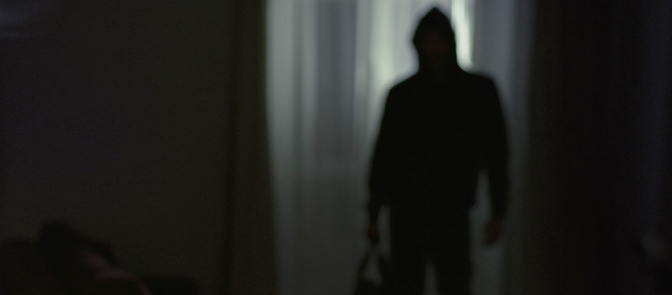 A shadowy figure enters a home