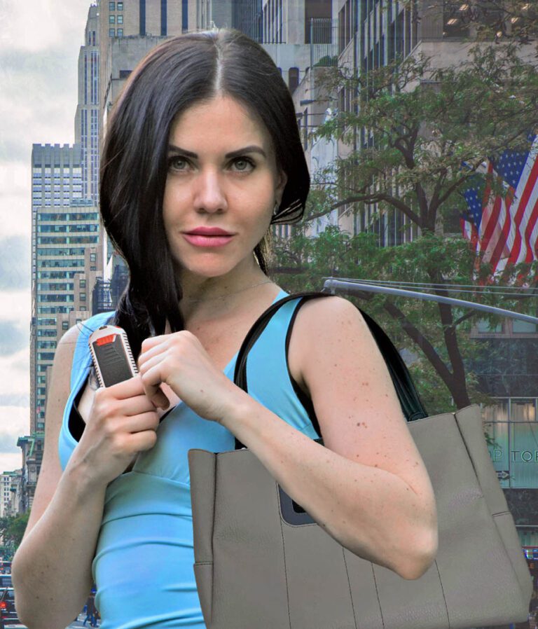 A woman holds her AIIRO with her MICHE handbag