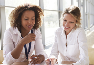 Two women look over documents together