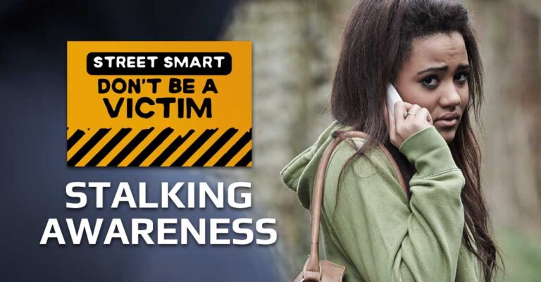 A young woman being followed holds her phone to her ear. She looks concernced